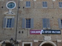 Lo striscione appeso davanti al comune 'Tagliamo le spese militari',