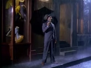 Gene Kelly nella scena in cui canta sotto la pioggia Singin' in the Rain