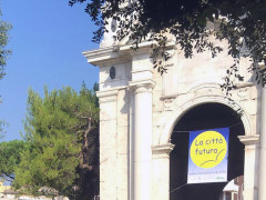 Lo striscione de La Città Futura in festa 2016 appeso su porta Lambertina in via Carducci