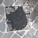 Rattoppi con il bitume tra i sampietrini di via Carducci a Senigallia
