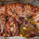 Coniglio arrosto intero avvolto nella pancetta