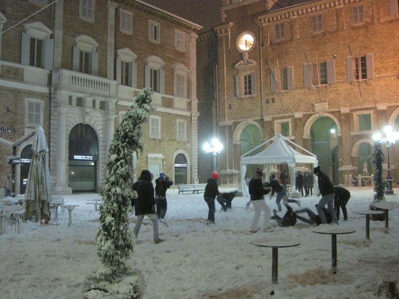 Ragazzi giocano nella neve in Piazza Roma, sotto la tormenta
