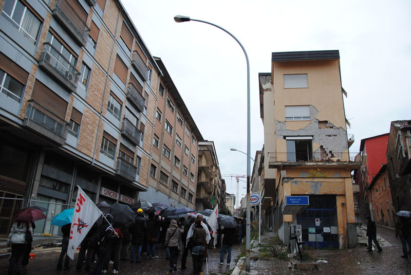 Il corteo tra i vari palazzi danneggiati dal sisma del 6 aprile 2009