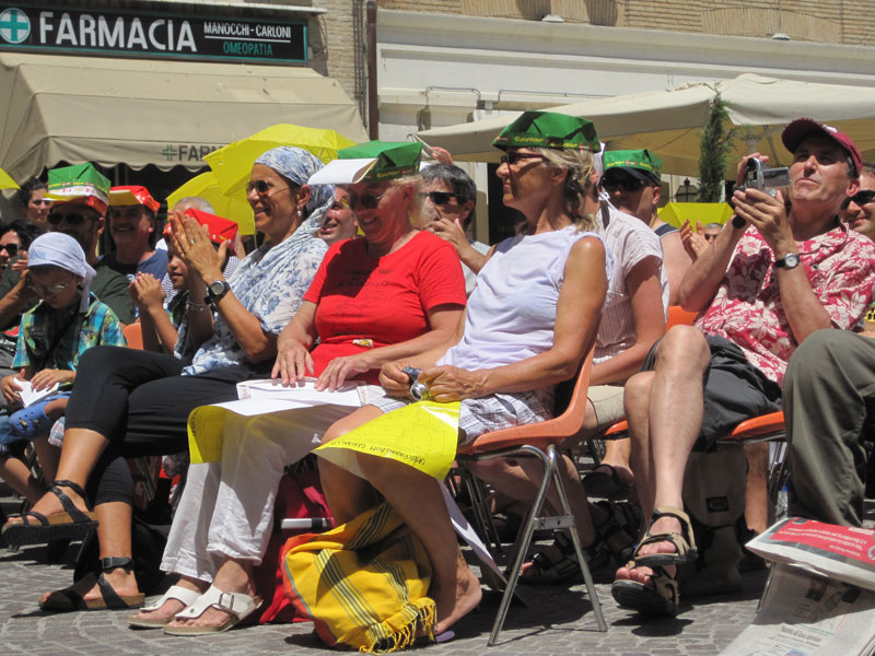 Spettatori al sole, ancora impegnati nella costruzione del cappellino garibaldino