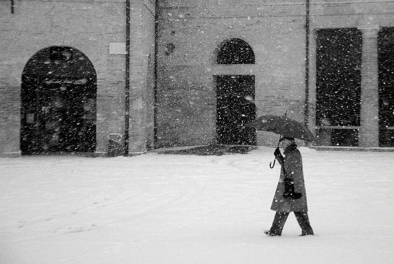 Un passante sotto la neve al Foro