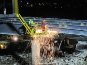 Operai staccano la struttura del ponte con la fiamma ossidrica