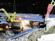 Operai staccano la struttura del ponte con la fiamma ossidrica