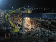 Operai staccano la struttura del ponte con la fiamma ossidrica