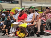 Spettatori al sole, ancora impegnati nella costruzione del cappellino garibaldino